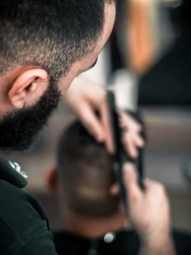 Barber shaping a fade with clippers